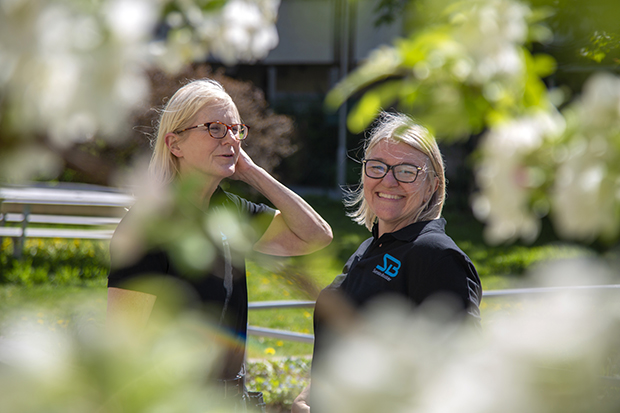 Två blonda kvinnor med glasögon står i solen.