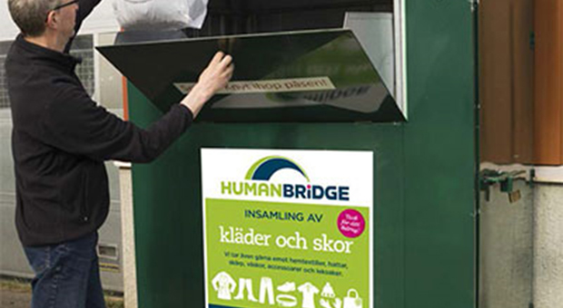 Man lämnar in en påse textilier i en insamlingskärl