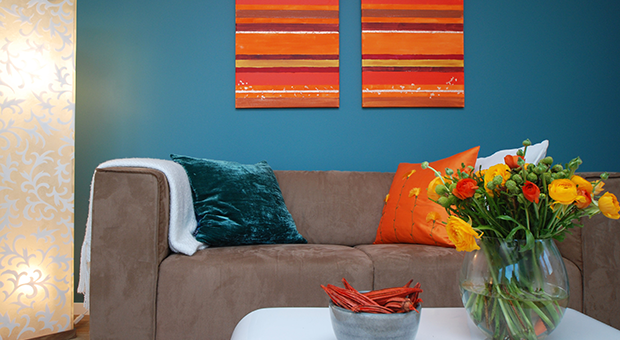 Inrett vardagsrum med blå vägg och brun soffa