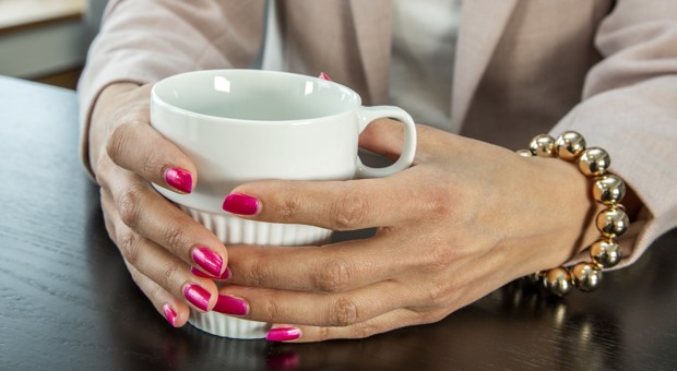 Händer runt en kaffekopp.