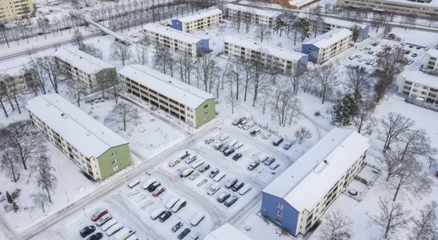 Flygbild över en vinterklädd parkering i Skärholmen.