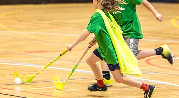 Barn spelar inomhusbandy.