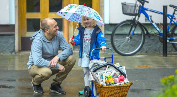 Pappa ler mot sin dotter som håller i ett paraply.