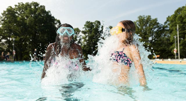 Tjejer dyker upp ur poolen.