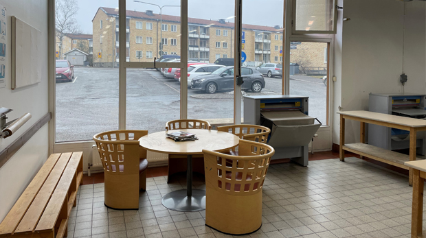 Liten sittgrupp i trä i nyrenoverad tvättstuga med stort ljusinsläpp.